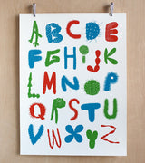 Makelike cactus alphabet poster with vibrant red, blue, green letters and varied textures.