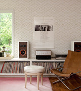Off-white geometric wallpaper featuring a light gold retro interlocking pattern.