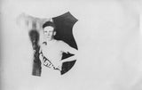 Shield-shaped black and white antique photograph of a boy with 'Loyal' sash, circa 1912.