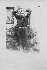 Antique experimental black and white photograph of a young man, hands behind head.