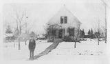 Late 1910s surreal black and white photograph of a snowy gabled house.