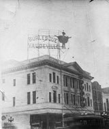 Aged black and white period photo of the 'Burlesque' sign and performer silhouette.
