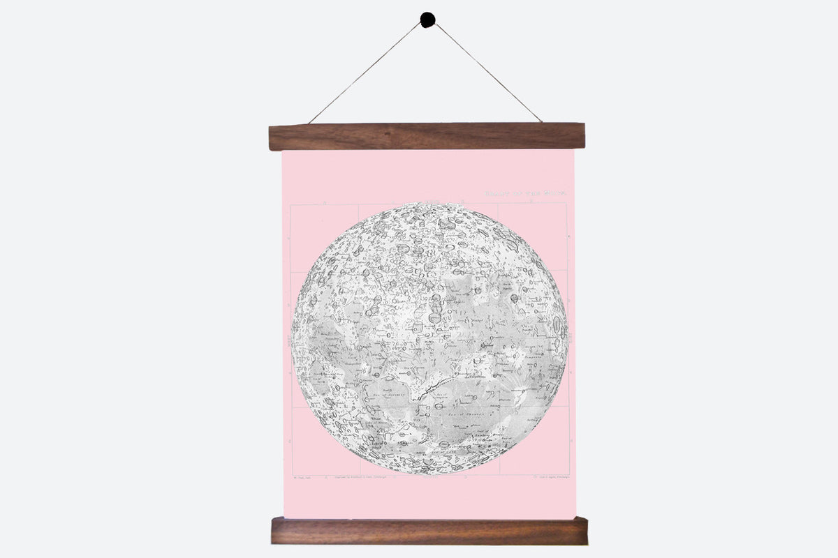 A vintage-style moon chart on pink canvas, complete with its walnut hanging rods.