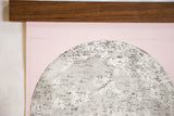 Detailed moon chart print on pink canvas below its handmade walnut wood hanging rod.
