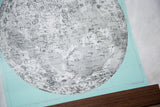 Intricate black and white moon chart details with craters against a mint canvas, walnut rod.