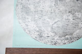 Detailed view of the mint antique moon chart on textured canvas, with walnut rod.