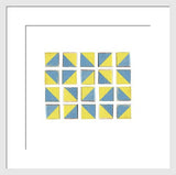Framed photograph of vintage geometric blocks arranged in a grid of blue and yellow diagonal patterns.