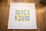 Full view of the geometric blocks photograph in its large, simple white gallery frame.