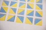 Angled detail of the photograph's distressed blue and yellow geometric block design.