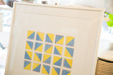 Angled view of the geometric photograph's clean white frame and wide matting.
