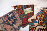 A collection of Rugling wall hangings showing various antique rug fragment styles, from pictorial roosters to geometric kilim patterns.