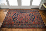 Intricate tribal Southwestern pattern with deep navy and autumnal colors on a vintage rug.
