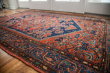 Tribal border detail with deep navy and autumnal orange patterns on the vintage rug.