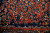 Excellent design detail in reddish-orange and navy tribal pattern on vintage rug.