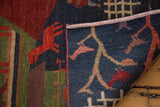 Hand-knotted Tibetan pictorial rug's plush wool pile, red and indigo patterns, and woven back.