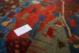 Pictorial folk art motifs in red, indigo blue, and green on a plush Tibetan rug.