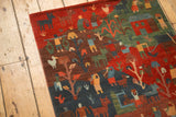 Hand-knotted Tibetan Folk Art rug, stylized figures, trees on plush madder red and indigo pile.