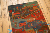 Pictorial Tibetan folk art rug with colorful village scene of homes, people, and animals.