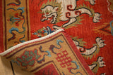 Tibetan Fu dog rug showing plush red pile with subtle carving and patterned golden border.
