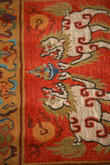 Plush pile of ivory Fu dogs on madder root red, with a rich multicolored border.