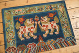 Tibetan Fu Dog rug corner, plush indigo blue pile contrasting stylized sage green border.