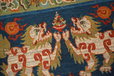 Plush ivory Fu dogs and carved central motif on indigo blue Tibetan rug.