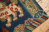 Tibetan Fu Dog rug's carved plush pile, with indigo blue field and colorful cloud motifs.