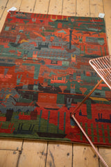 Hand-knotted folk art rug corner with plush carved pile in madder red and teal green.