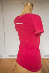Back of the watermelon red scoop neck tee with white contrast stitching and brand text.