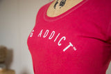 Contrast stitching on the scoop neckline and white block lettering of a watermelon red t-shirt.