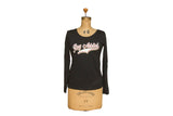 Women's black long-sleeve shirt with a retro 'Rug Addict' script graphic in pink and white.