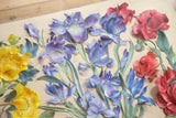 Close-up of layered blue irises and red poppies in 3D flower art.