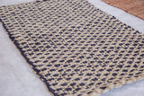 Rowan jute rug displaying tight woven texture with undyed natural and navy grid pattern.