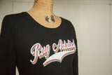 Close-up of the 'Rug Addict' retro graphic with layered colors on a black t-shirt.