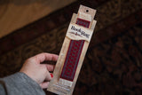 Bokhara Rug Bookmark with rich red field, stylized ivory and blue Turkoman design.