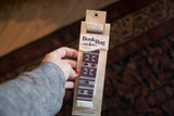 Packaged Earthtone Southwest BookRug bookmark with geometric pattern and fringe.
