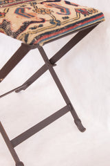 Detail of the industrial folding metal base of the rug fragment footstool.