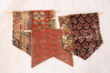 Three unique antique RUGLING wall hangings on dowels, showcasing traditional Persian patterns.