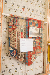 Geometric pattern and woven texture of the antique Soumac rug fragment cork board with pinned notes.