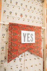 A note pinned to the antique rug fragment, demonstrating the RUGLING's cork board function.