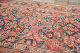 Shabby antique Persian Kurdish rug detail with faded pinkish-red tribal Herati pattern and arabesque border.