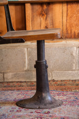 Adjustable threaded iron post and flared cast iron base of the antique school chair.