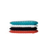 Stacked Sunbrella pads in teal, white, black, and orange with ribbed texture.