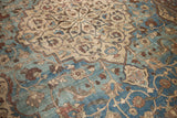 Softened aqua blue field with beige medallion and scrolling vines on a distressed vintage Tabriz carpet.