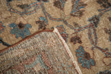 Texture detail of vintage distressed Tabriz carpet, showing hand knotted back and faded beige field.