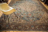 Distressed brick red border and aqua blue scrolling vines on vintage Tabriz carpet.
