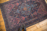 Distressed Malayer rug with aqua blue diamond medallion, fish motifs, blush rose, navy tones.