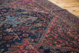 Distressed vintage Malayer rug with navy, blush, aqua patterns and zig-zag border.