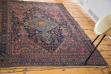 Tattered fringe and detailed border of a distressed Malayer rug with blush rose tones.