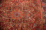 Vibrant red field with floral motifs, scrolling palmette border, and brown boots.